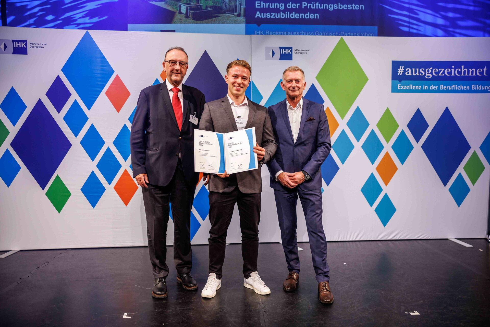 Hubert Schöffmann (re.), IHK-Bereichsleiter Berufliche Bildung, und Reinhard Häckl, Vorsitzender des IHK-Regionalausschusses Landsberg am Lech (stellvertretend für das regionale IHK-Ehrenamt), gratulieren Oberbayerns bestem Kaufmann für Digitalisierungsmanagement am 26.10.2023 im Münchner GOP Varieté Theater