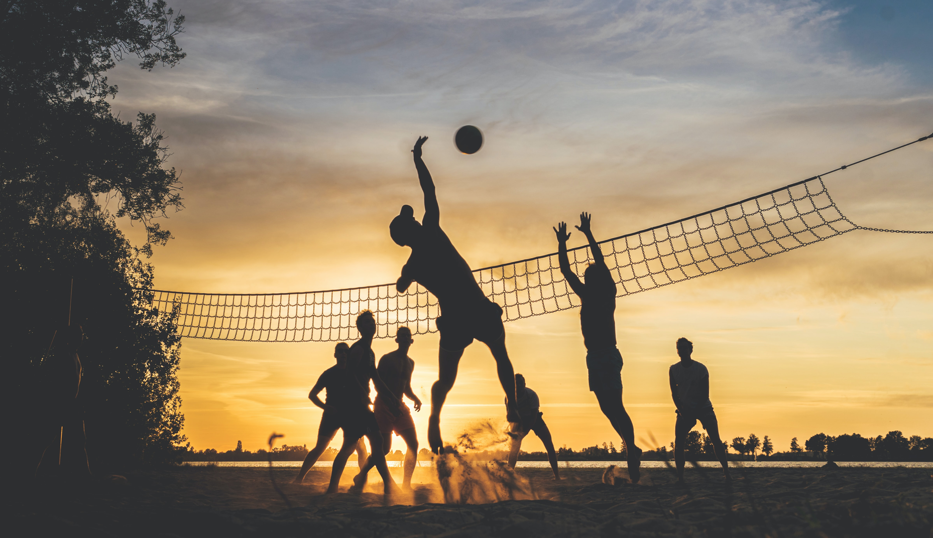 A group of friends play beach volleyball while the sun is setting. Taken on a warm summer evening at the Loosdrechtse Plassen in the Netherlands. | © Unsplash / Jannes Glas