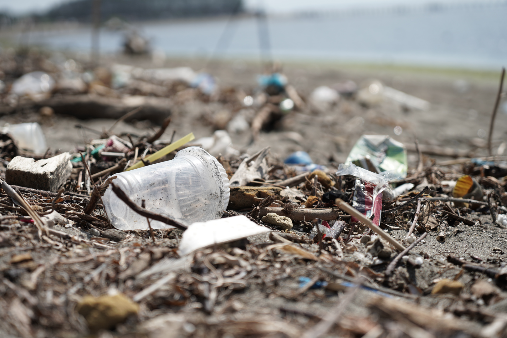 Plastic pollution on the beach in Bali, before Ocean Cleanup Group operation. Plastic cups on the beach. Plastic waste | © Unsplash / OCG Saving The Ocean