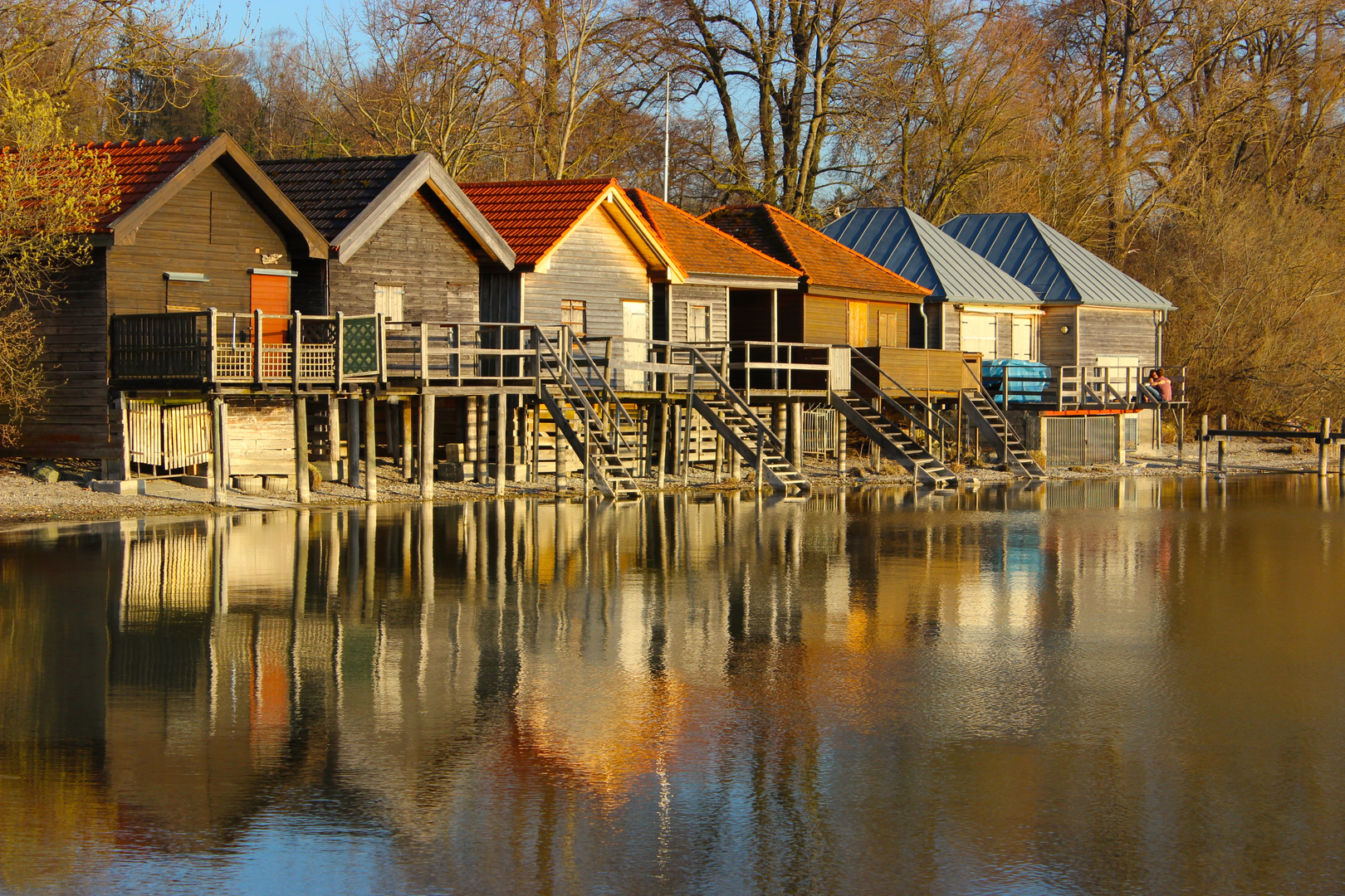 boat sheds and fall trees at Ammersee near Munich | © Unsplash / Michael Geiger