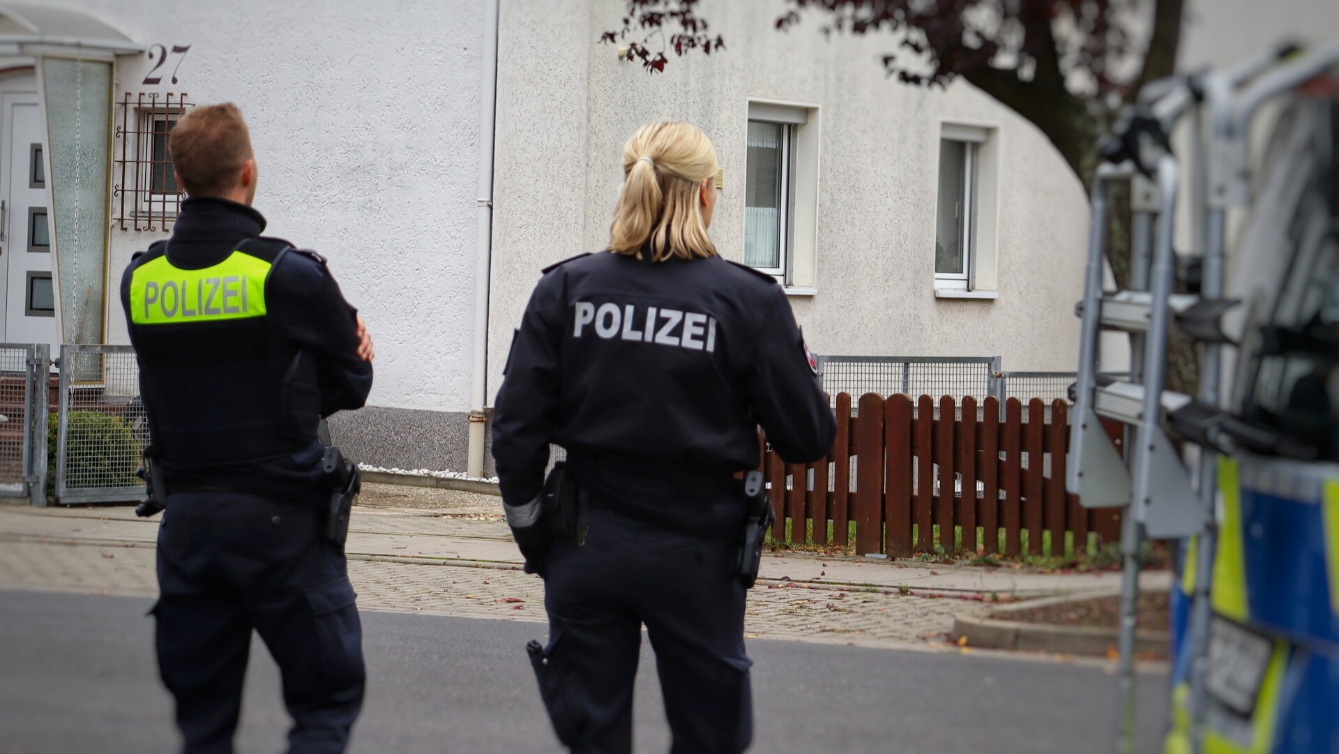 Polizeibeamten neben einem Funkstreifenwagen
