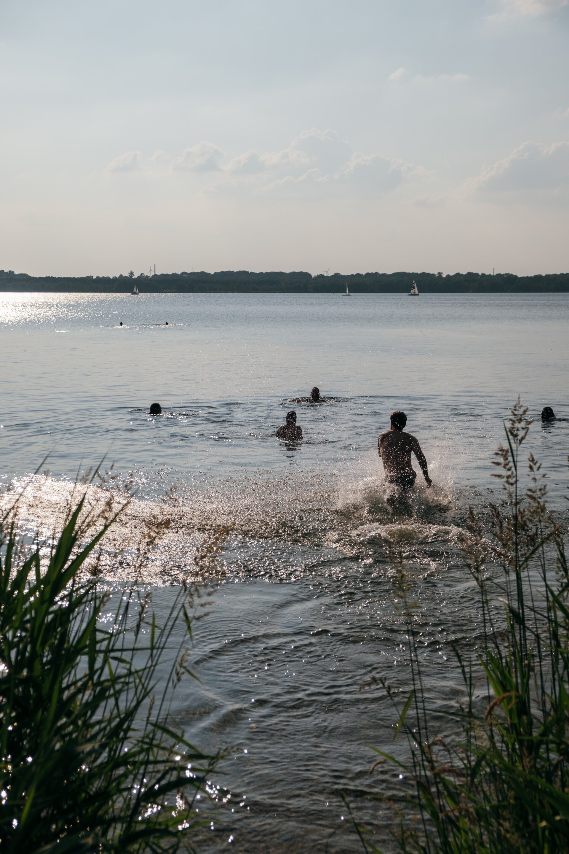 Friends jumping into a cold lake on a hot summer day