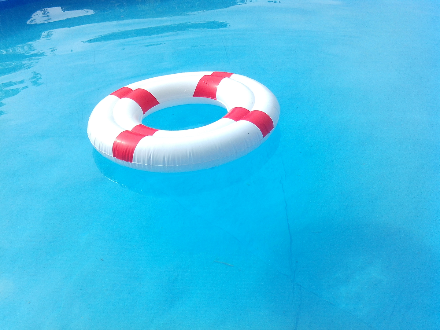 red and white inflatable ring on beautiful clear blue water | © Unsplash / Lidia Nikole