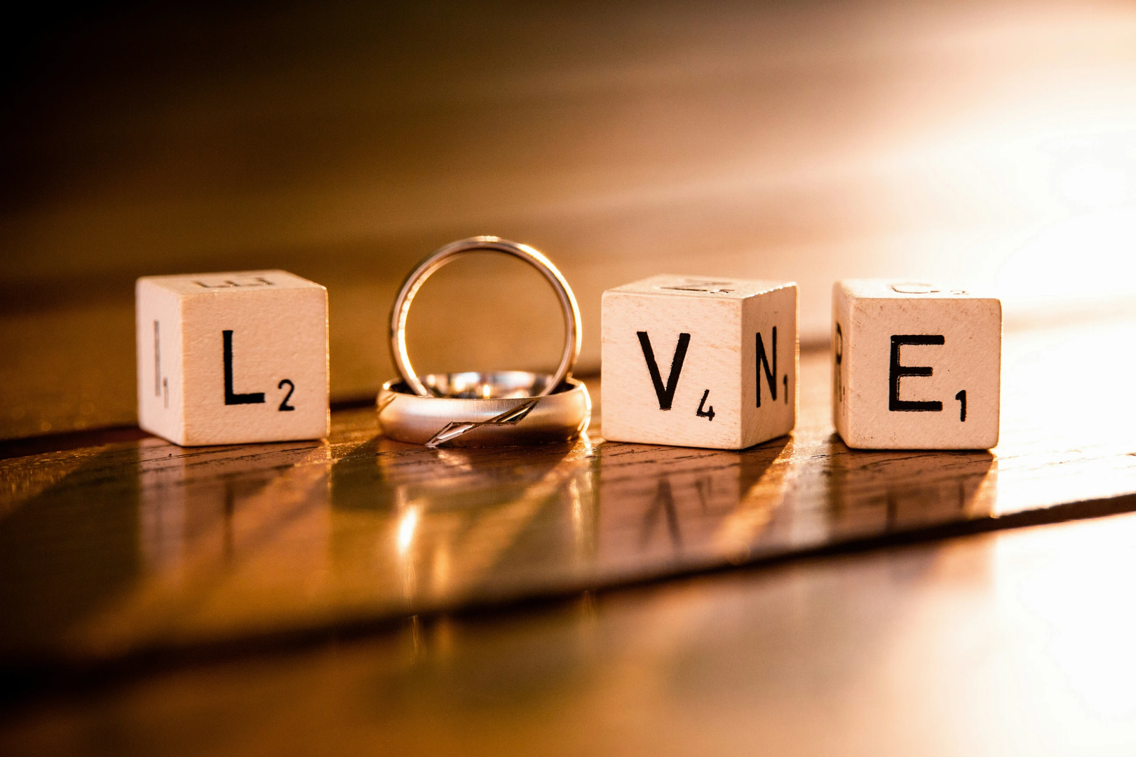 Dices and wedding rings that shows the word "love" | © Unsplash / Denny Müller