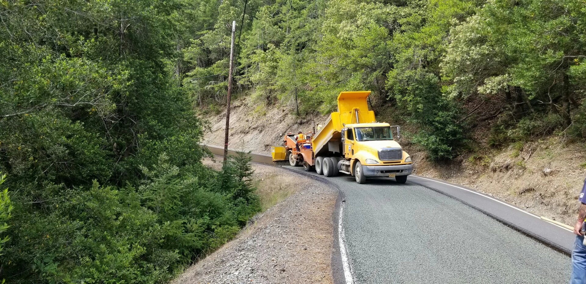 Chip sealing a county road in the mountains.