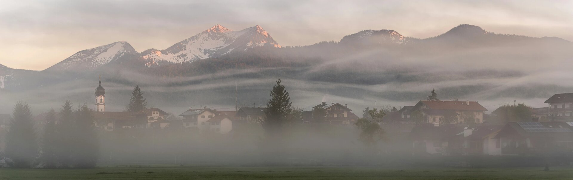 Waves of fog sweep over the village Krün