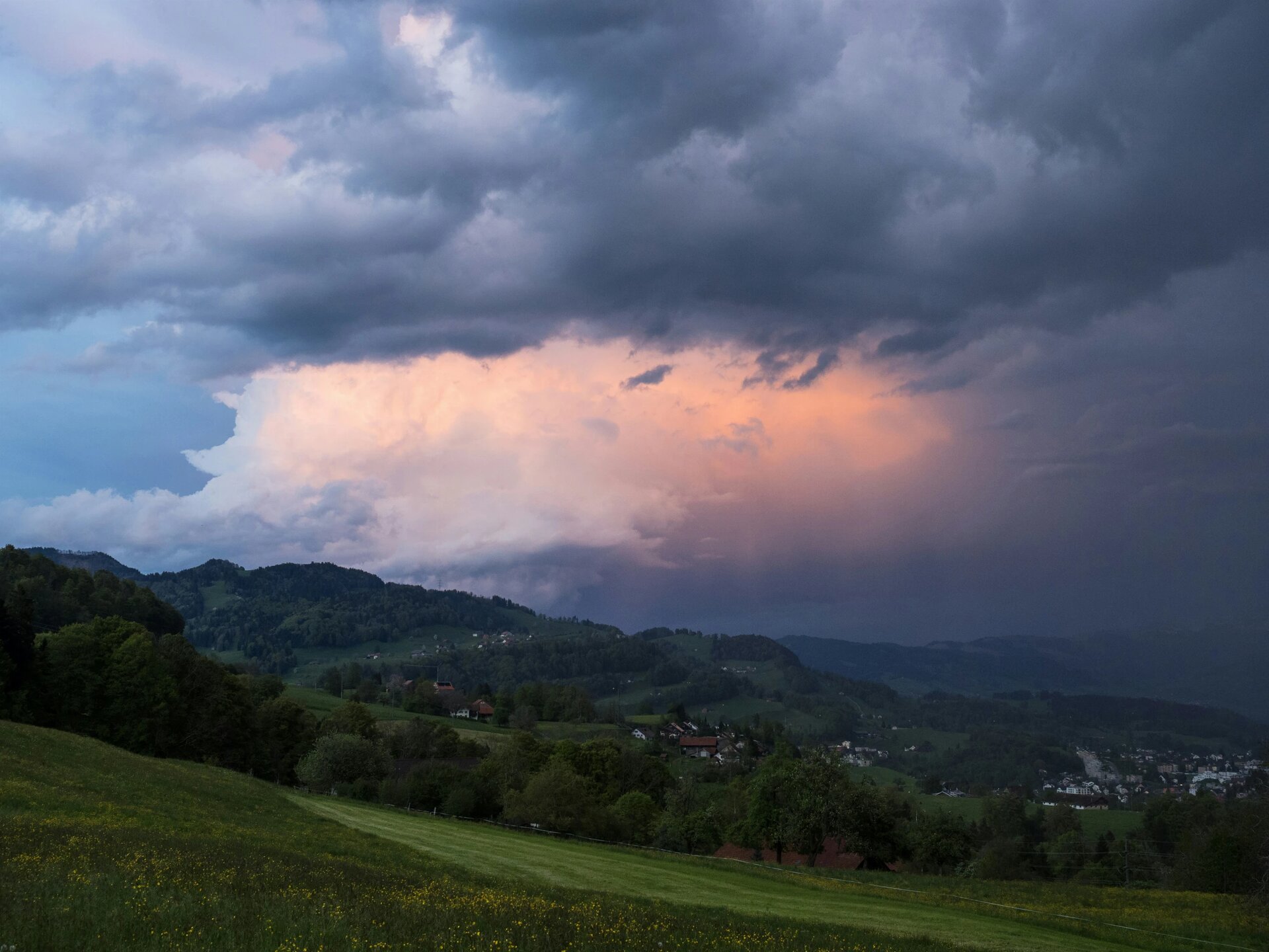Bedrohliche Wetterveränderung über Hügellandschaft. Glühend leuchtende Wolken.