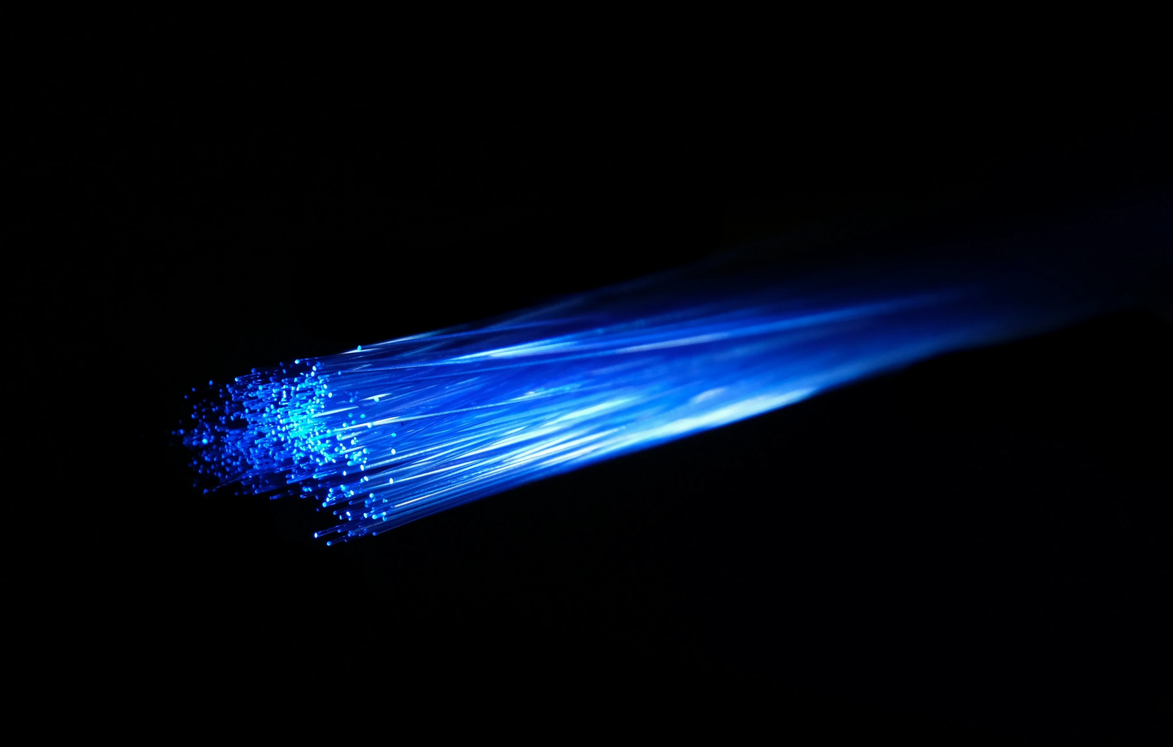 Blue light passing over fibre optic cable. The fiber optic is very vivid and striking. Ideal image for depicting superfast gigabit fibre broadband, networks, networking and other internet technology. | © Unsplash / Compare Fibre