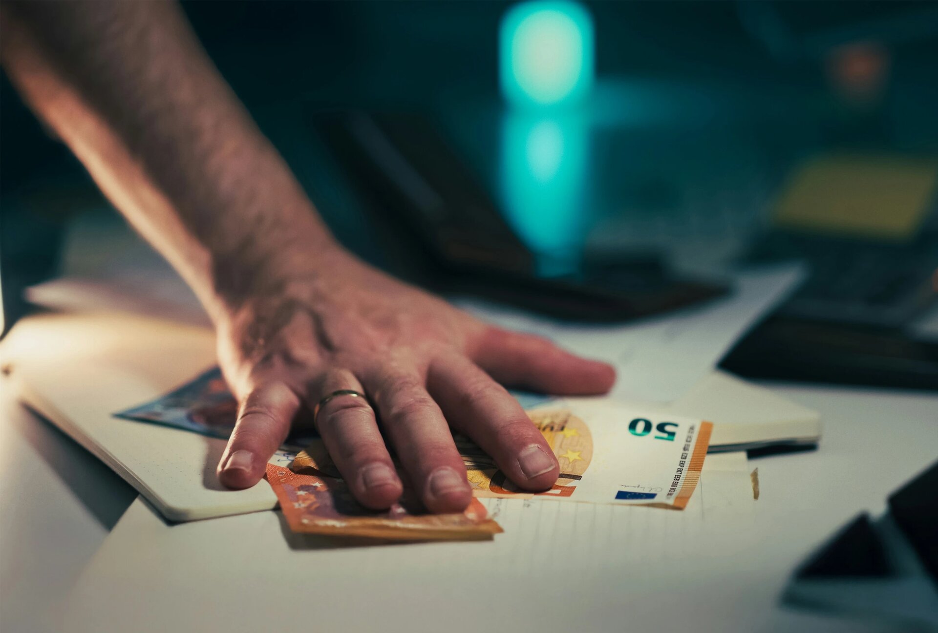 Hand Grabbing Euro Banknotes Desk. Fast male hand movement over scattered euro bills lying on office desk