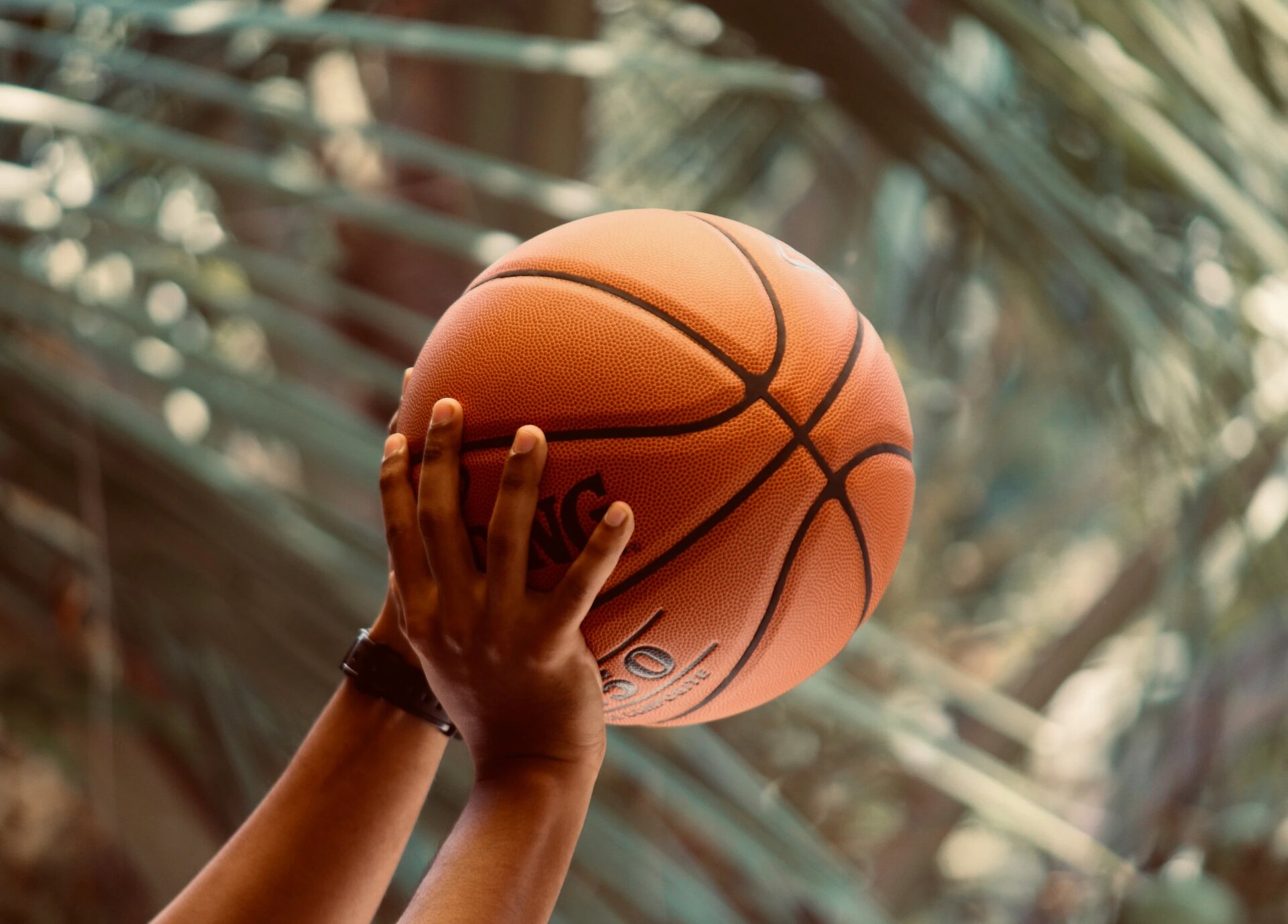 Man shooting a Spalding basketball. 
Image by Abhay Siby Mathew. 