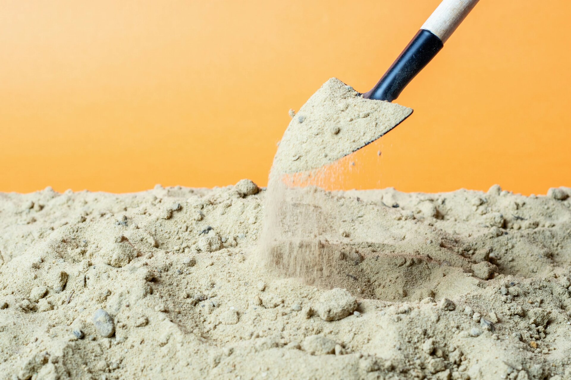 sand spills from a shovel